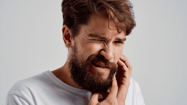 Image of man with tooth pain requiring emergency dental care